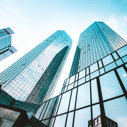 istockphoto-1137991385-612x612 Low wide-angle view looking up to modern skyscrapers in business district on a beautiful sunny day with blue sky and clouds